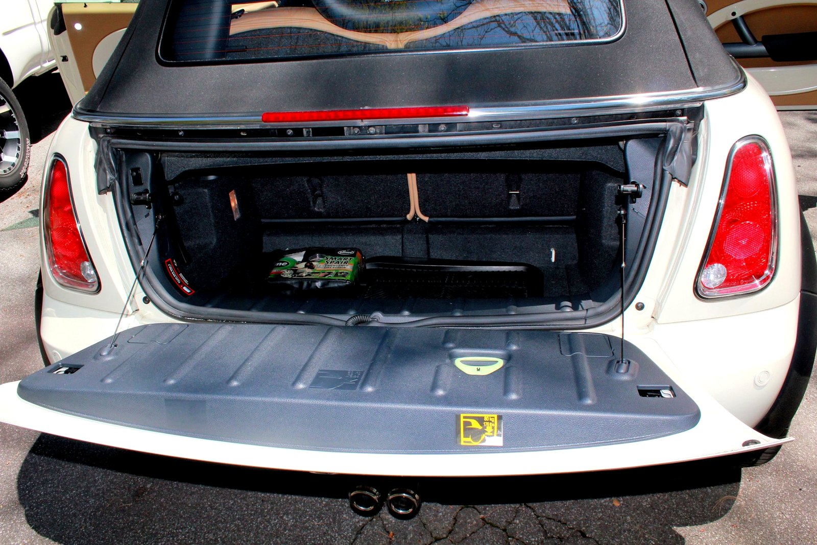 Open rear cargo area of a white MINI convertible showing the trunk space, trim, and interior condition.